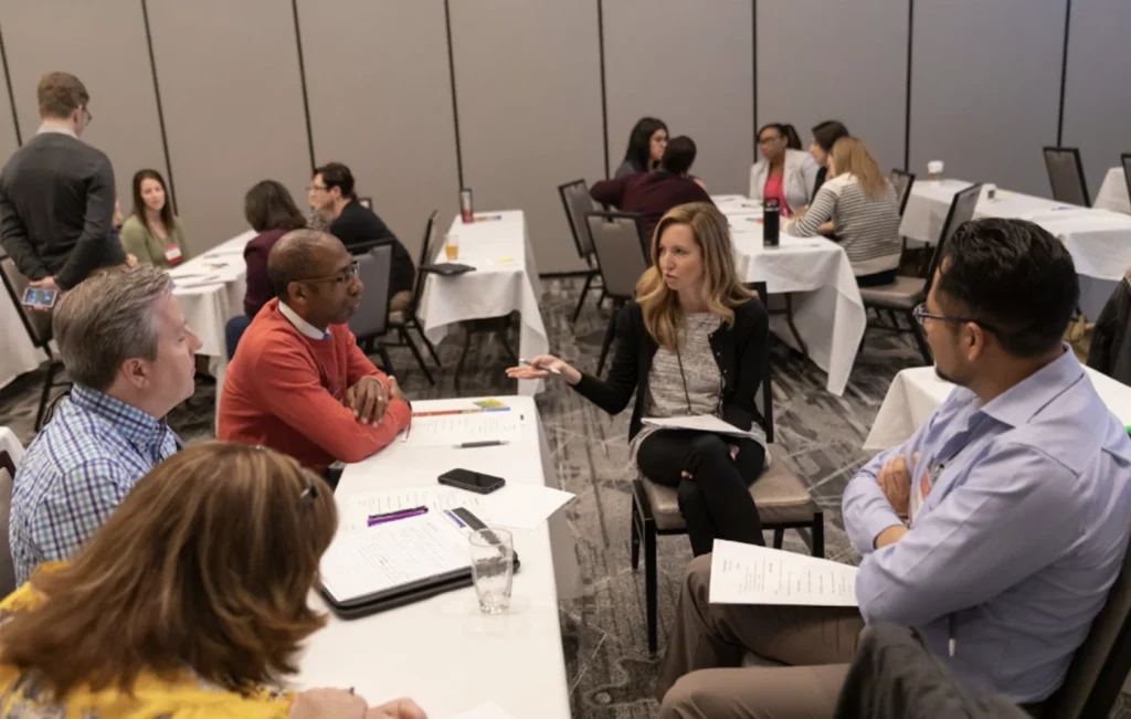 Three tables with groups of attendees each having a discussion together.