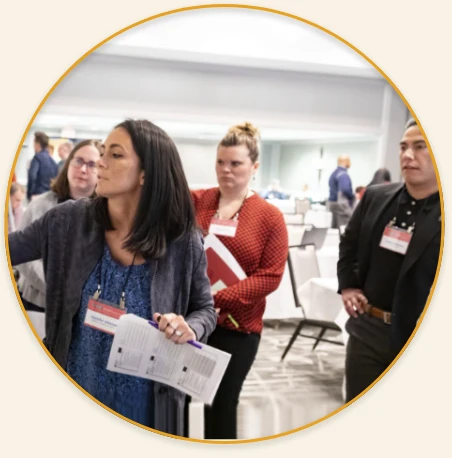 Group of four participants doing a small group activity. One participant is working on something out of view while the others observe.