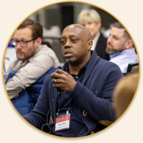 Institute attendee in the audience speaking on a small microphone.